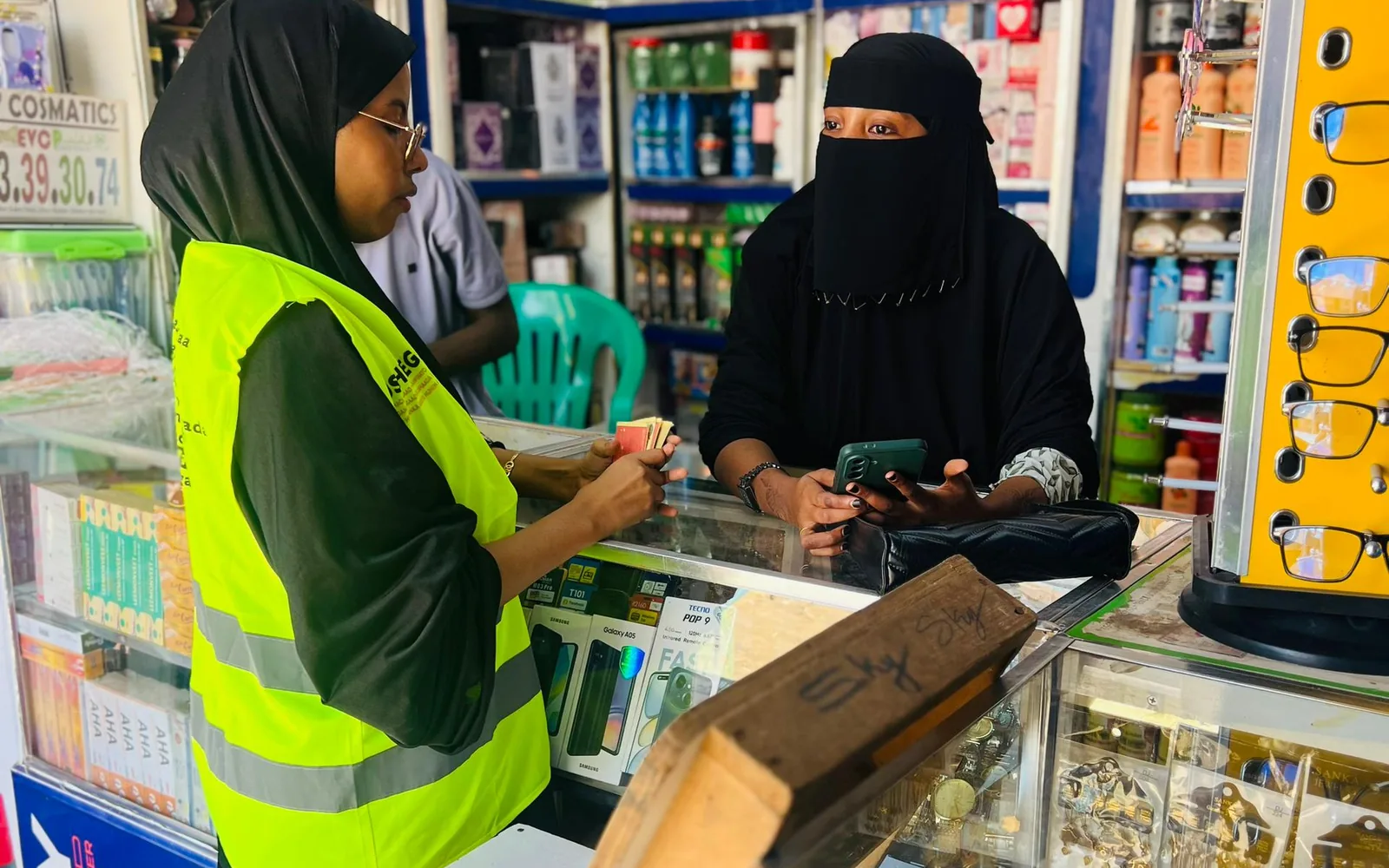 A Sauti field officer speaks with a woman business owner inside a local shop in Jowhar, Somalia.